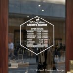 Custom open hours decal applied on wooden glass door, business storefront vinyl lettering, personalized store hours sticker by TheRetractableBanner.Shop