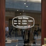 Custom open hours decal applied on wooden glass door, business storefront vinyl lettering, personalized store hours sticker by TheRetractableBanner.Shop