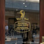 Custom open hours decal applied on wooden glass door, business storefront vinyl lettering, personalized store hours sticker by TheRetractableBanner.Shop