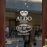 Custom open hours decal applied on wooden glass door, business storefront vinyl lettering, personalized store hours sticker by TheRetractableBanner.Shop