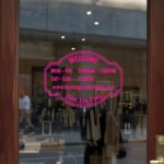 Custom open hours decal applied on wooden glass door, business storefront vinyl lettering, personalized store hours sticker by TheRetractableBanner.Shop