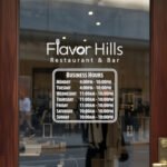 Custom open hours decal applied on wooden glass door, business storefront vinyl lettering, personalized store hours sticker by TheRetractableBanner.Shop