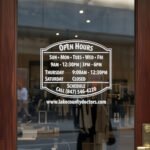 Custom open hours decal applied on wooden glass door, business storefront vinyl lettering, personalized store hours sticker by TheRetractableBanner.Shop