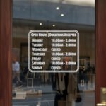 Custom open hours decal applied on wooden glass door, business storefront vinyl lettering, personalized store hours sticker by TheRetractableBanner.Shop