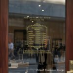 Custom open hours decal applied on wooden glass door, business storefront vinyl lettering, personalized store hours sticker by TheRetractableBanner.Shop