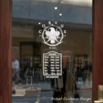 Custom open hours decal applied on wooden glass door, business storefront vinyl lettering, personalized store hours sticker by TheRetractableBanner.Shop