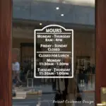 Custom open hours decal applied on wooden glass door, business storefront vinyl lettering, personalized store hours sticker by TheRetractableBanner.Shop