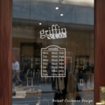 Custom open hours decal applied on wooden glass door, business storefront vinyl lettering, personalized store hours sticker by TheRetractableBanner.Shop