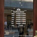 Custom open hours decal applied on wooden glass door, business storefront vinyl lettering, personalized store hours sticker by TheRetractableBanner.Shop