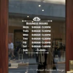 Custom open hours decal applied on wooden glass door, business storefront vinyl lettering, personalized store hours sticker by TheRetractableBanner.Shop
