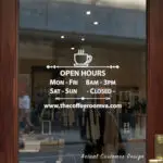Custom open hours decal applied on wooden glass door, business storefront vinyl lettering, personalized store hours sticker by TheRetractableBanner.Shop