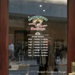 Custom open hours decal applied on wooden glass door, business storefront vinyl lettering, personalized store hours sticker by TheRetractableBanner.Shop