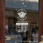 Custom open hours decal applied on wooden glass door, business storefront vinyl lettering, personalized store hours sticker by TheRetractableBanner.Shop